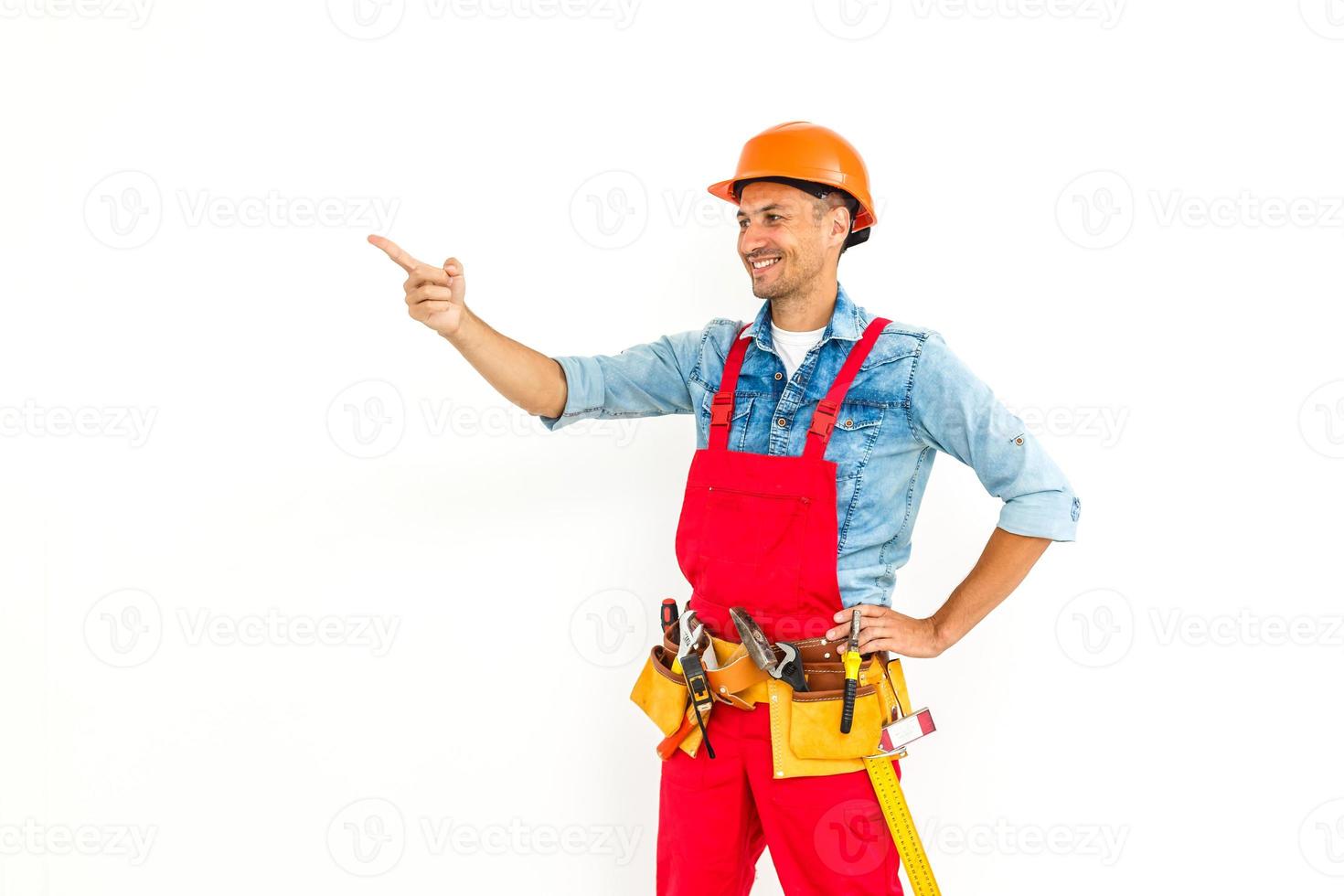 Serious construction worker in yellow helmet and orange looking up. Full length studio shot isolated on white. photo