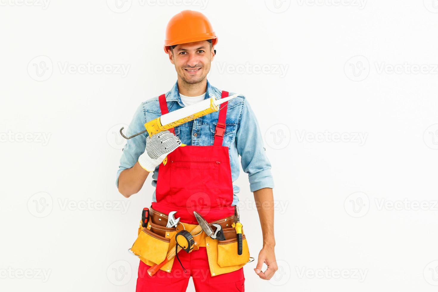 construction worker plasterer man uses caulking gun in building site of home renovation with tools photo