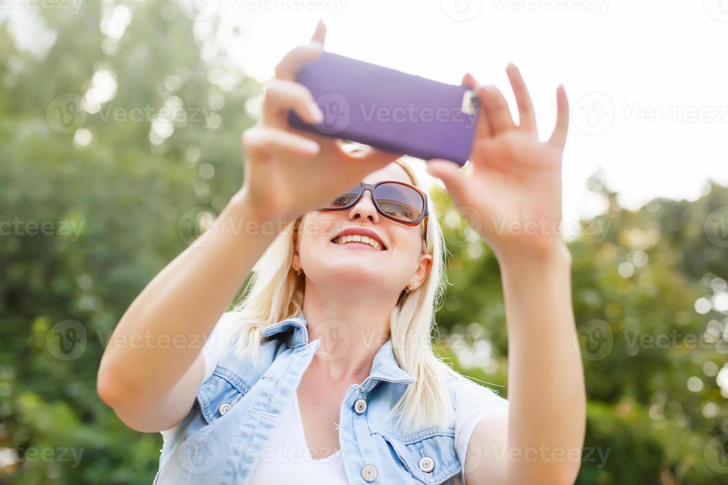 Smiling woman with a smartphone photo
