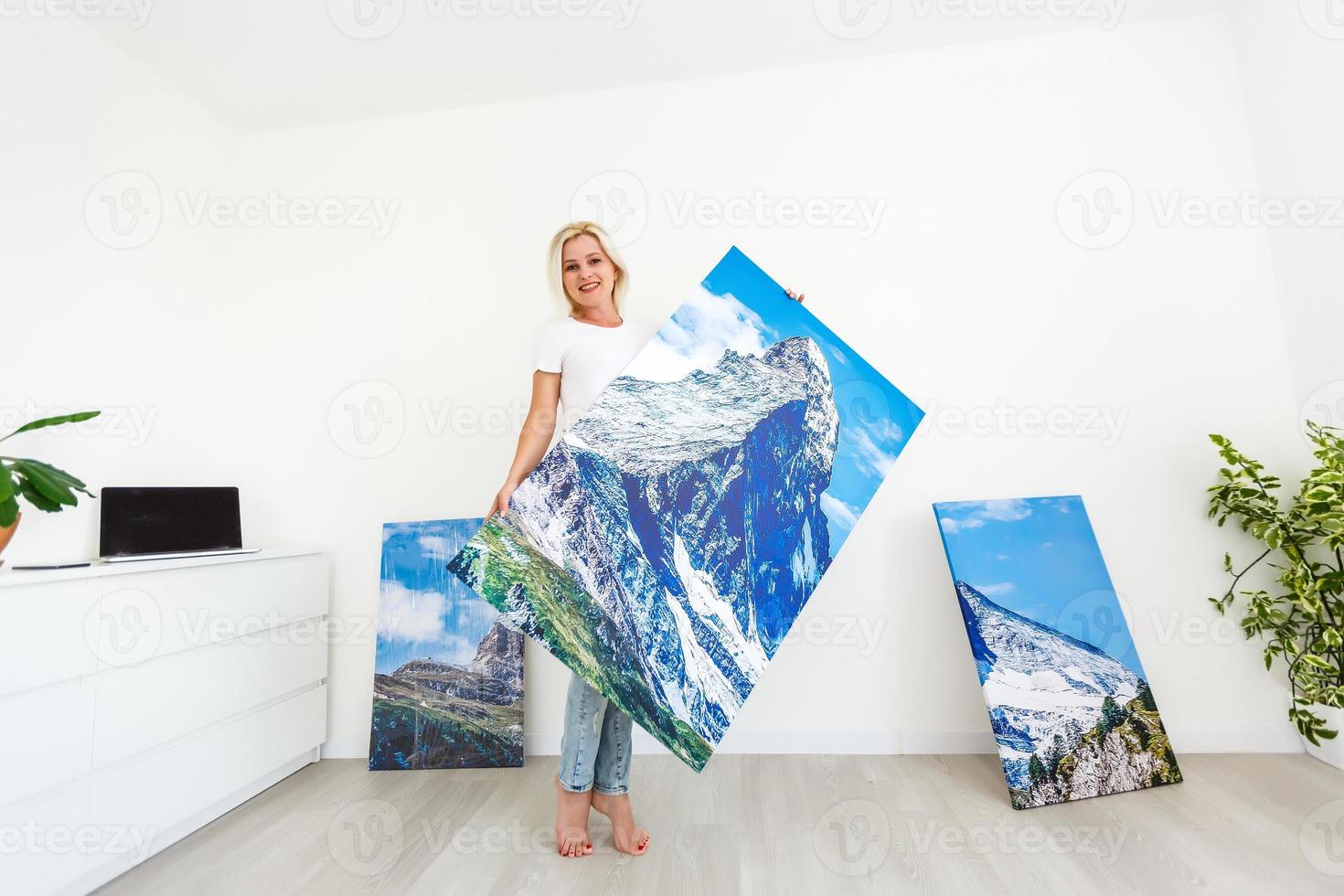 woman with a picture stands near the wall photo
