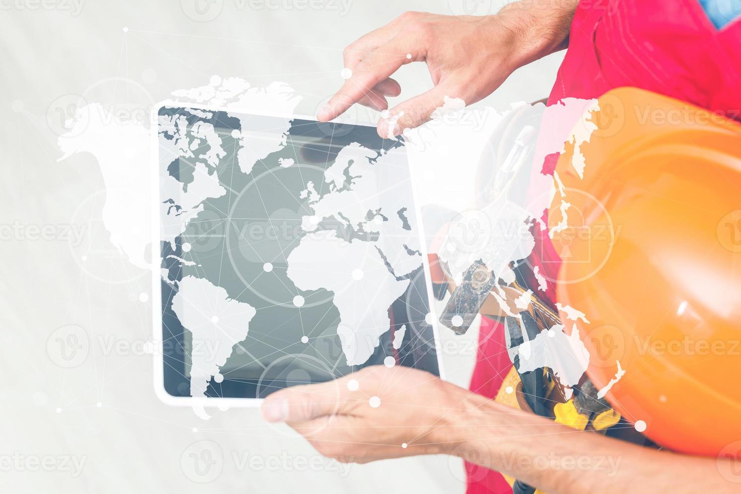 Side view man engineer wearing protective helmet using a tablet computer gadget choosing destinations on the world map. Modern technology artificial intelligence concept photo