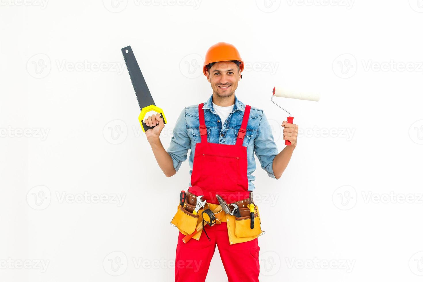 joven y amable trabajador manual en cuclillas aislado en blanco foto