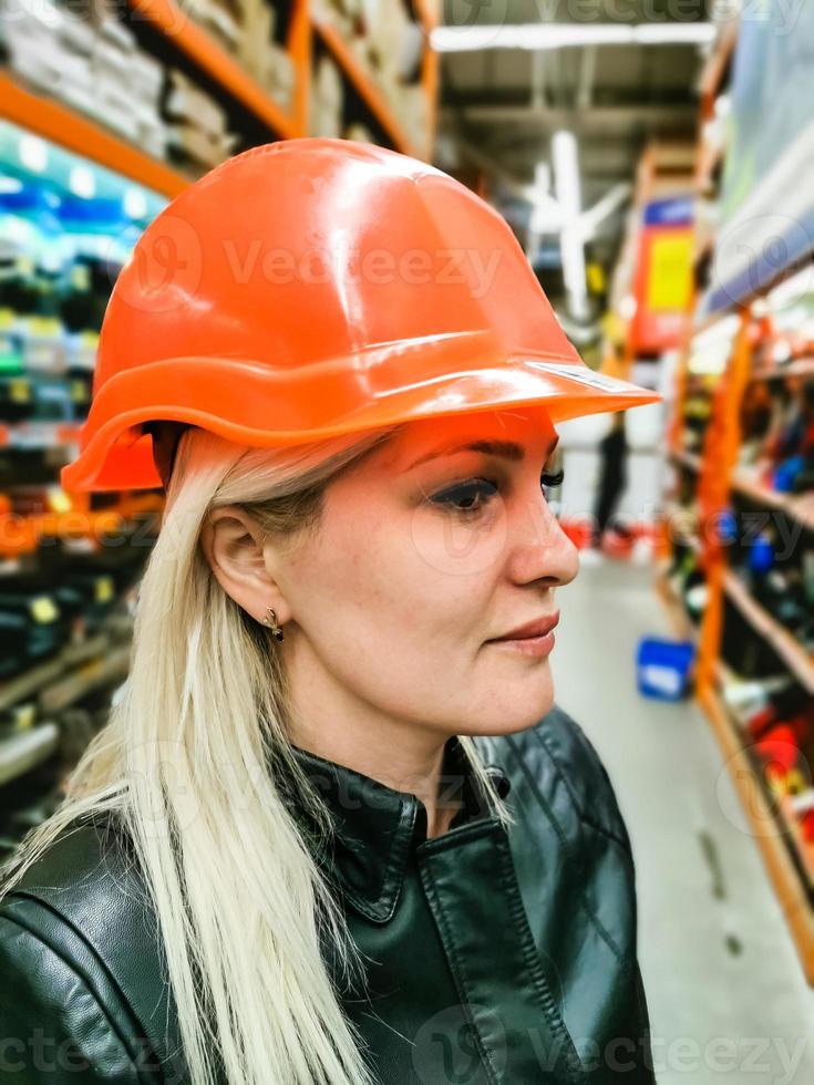 a woman measures a helmet in a store photo