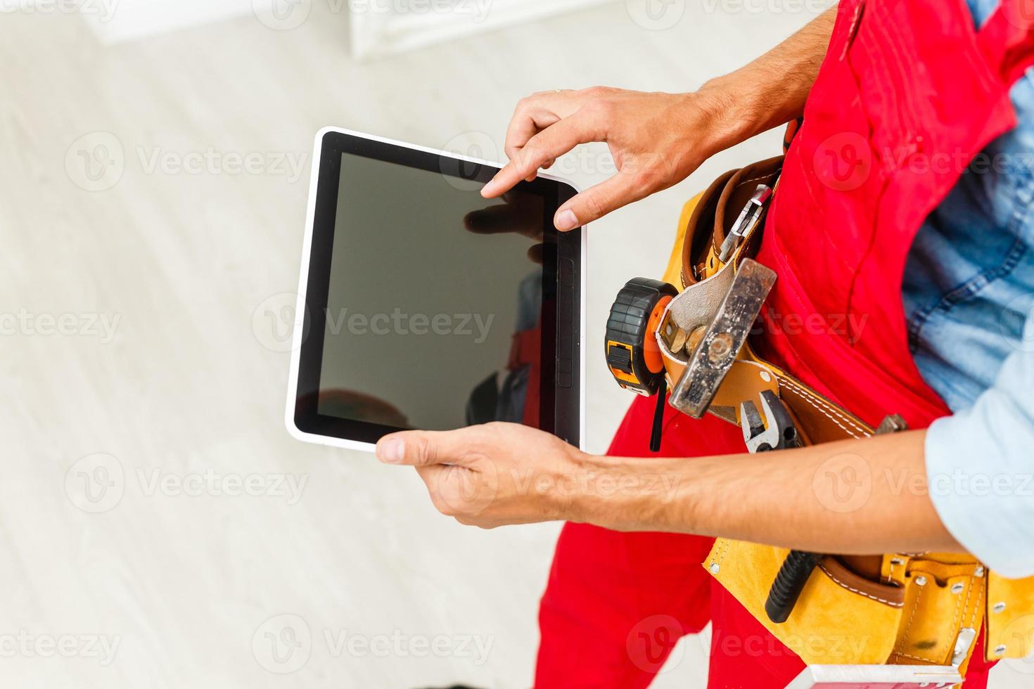Builder Holding Digital Tablet On White Background. photo