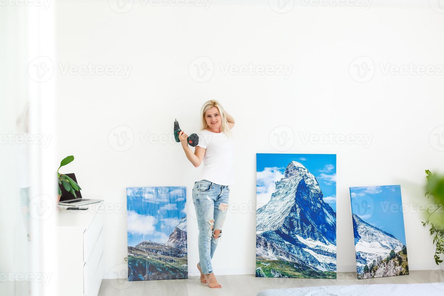 girl hangs a large photo canvas at home