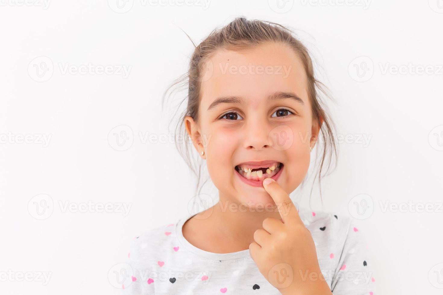 Little girl first tooth missing on a white background photo