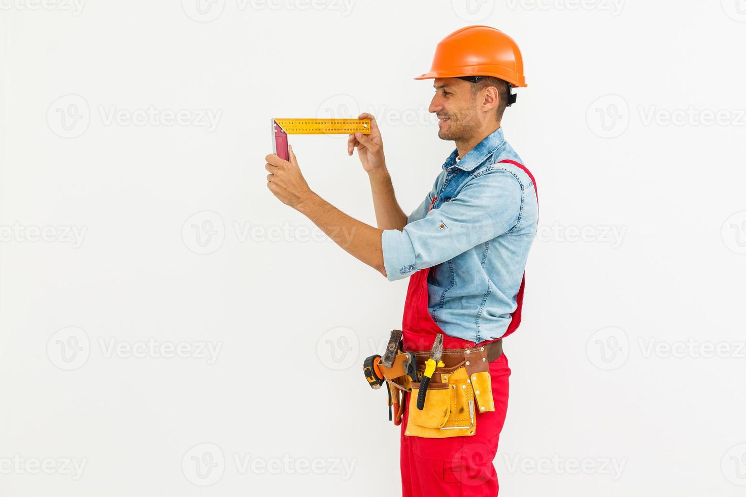 Profesión, construcción y construcción - trabajador masculino sonriente feliz o constructor en casco sobre fondo blanco. foto