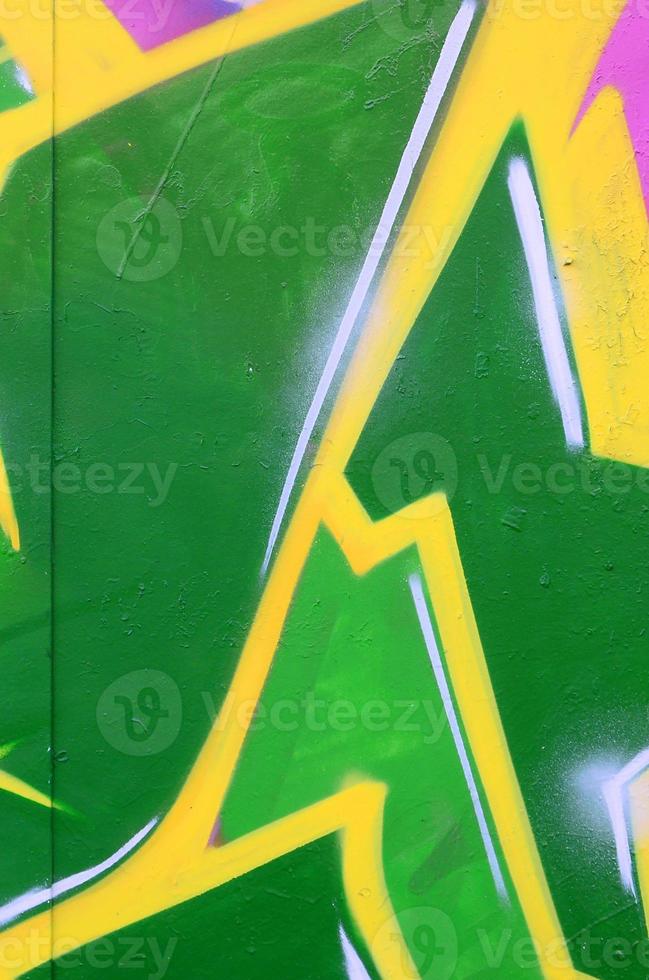 Fragment of graffiti drawings. The old wall decorated with paint stains in the style of street art culture. Colored background texture photo