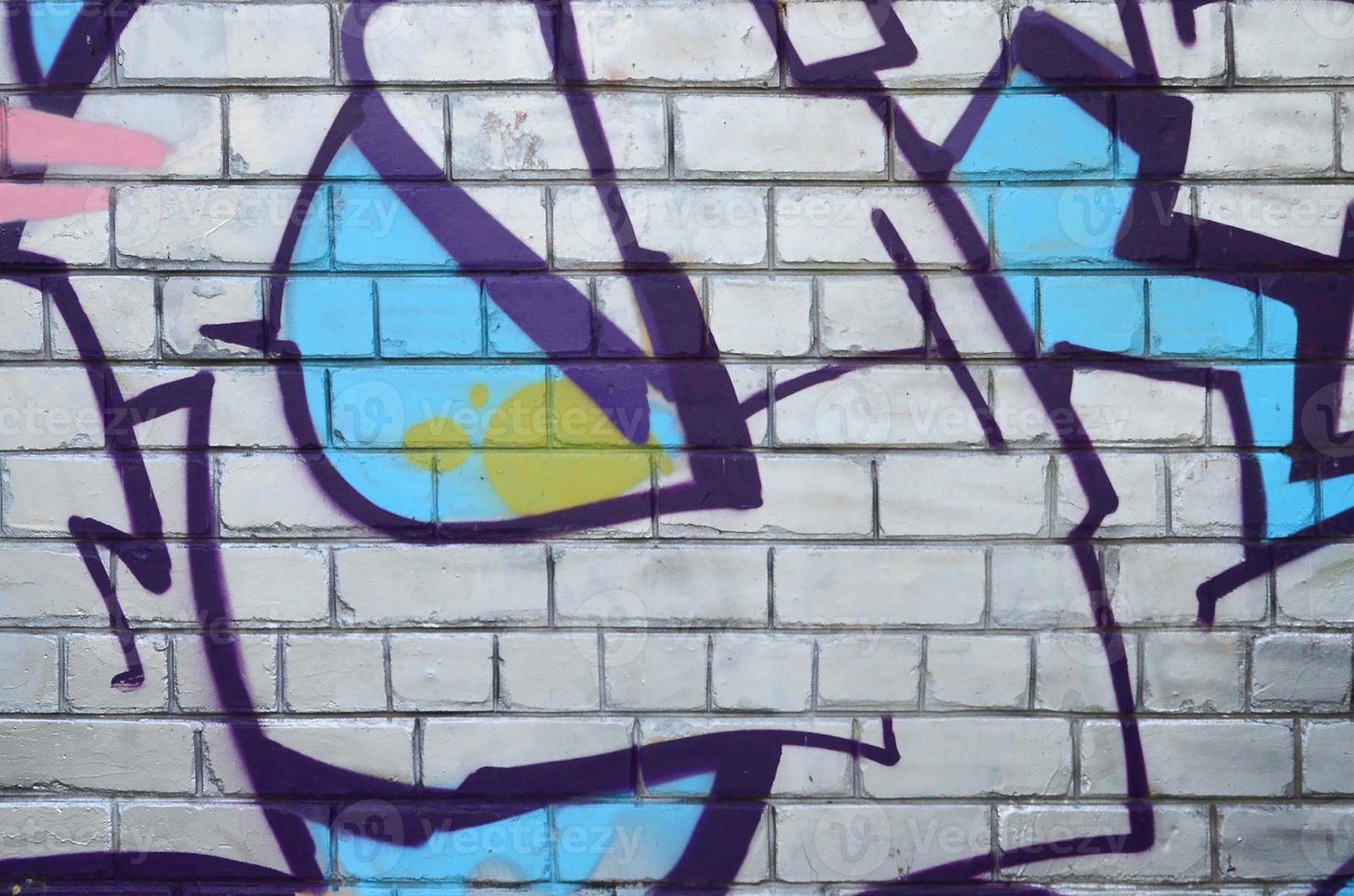Fragment of graffiti drawings. The old wall decorated with paint stains in the style of street art culture. Colored background texture photo
