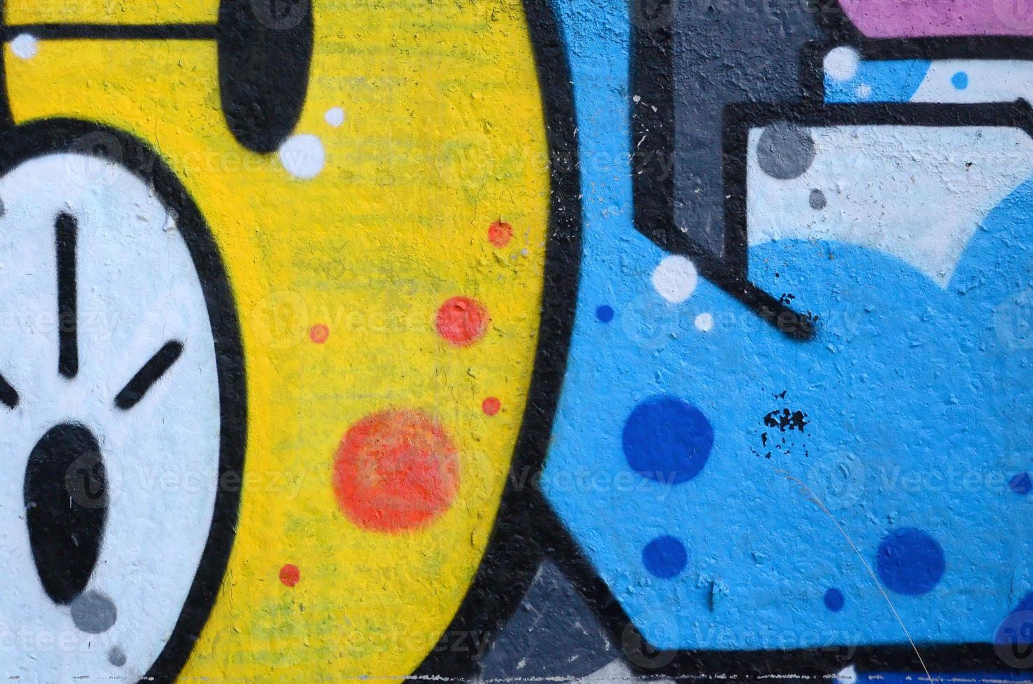 Fragment of graffiti drawings. The old wall decorated with paint stains in the style of street art culture. Colored background texture photo