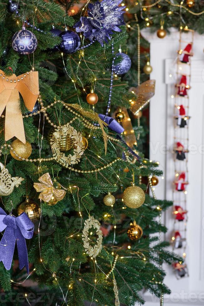 hermoso árbol de navidad con guirnaldas, pelotas y juguetes foto