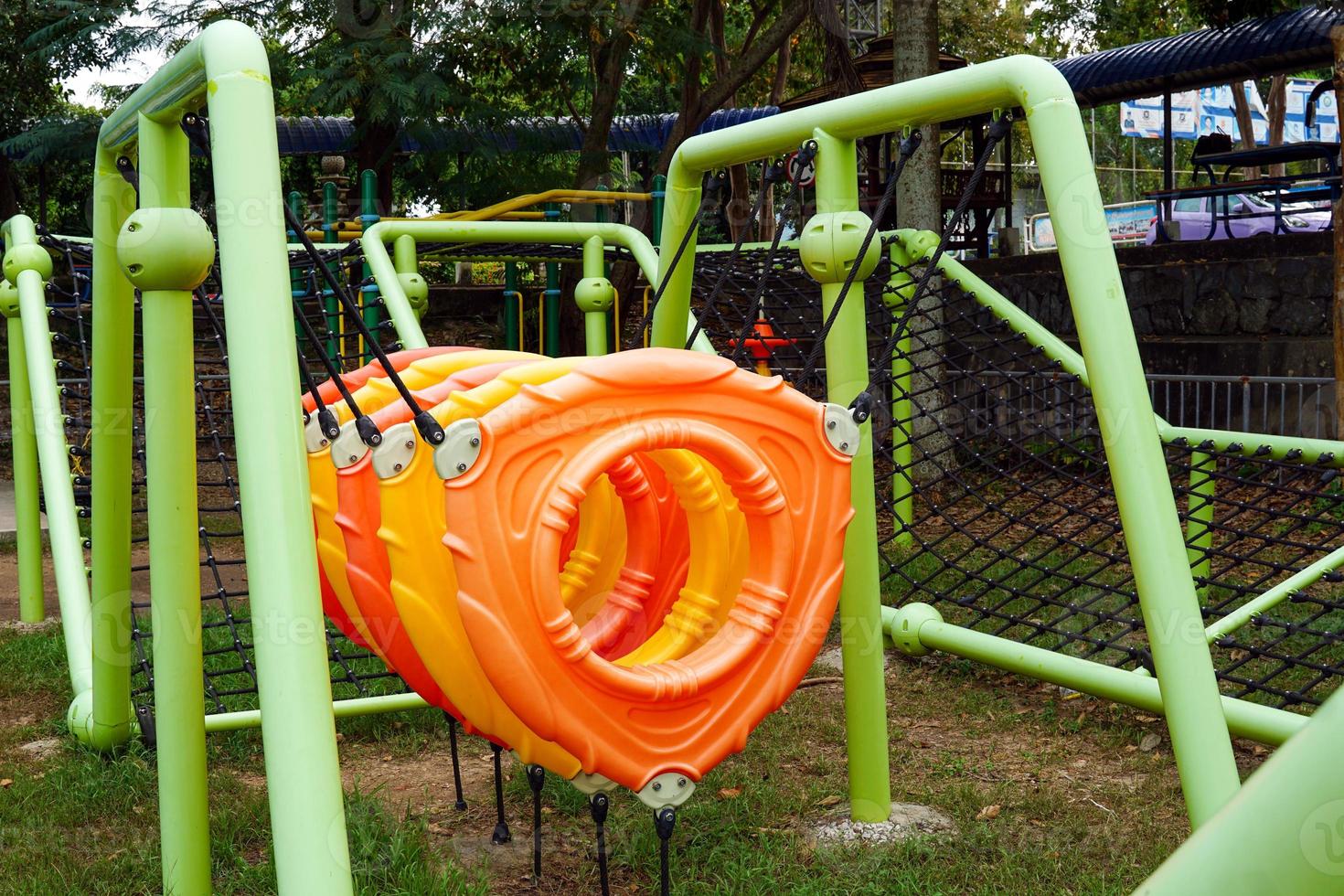 A set of climbing equipment in the outdoor playground with a climbing net and hoop. This will help enhance physical and mental development for children. photo