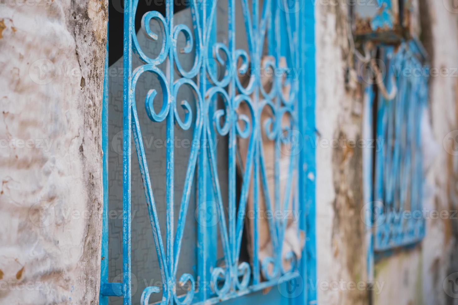 Metal grating painted with blue paint on an old house, selective focus on bars, ideas for a background or interior, renovation of old houses photo