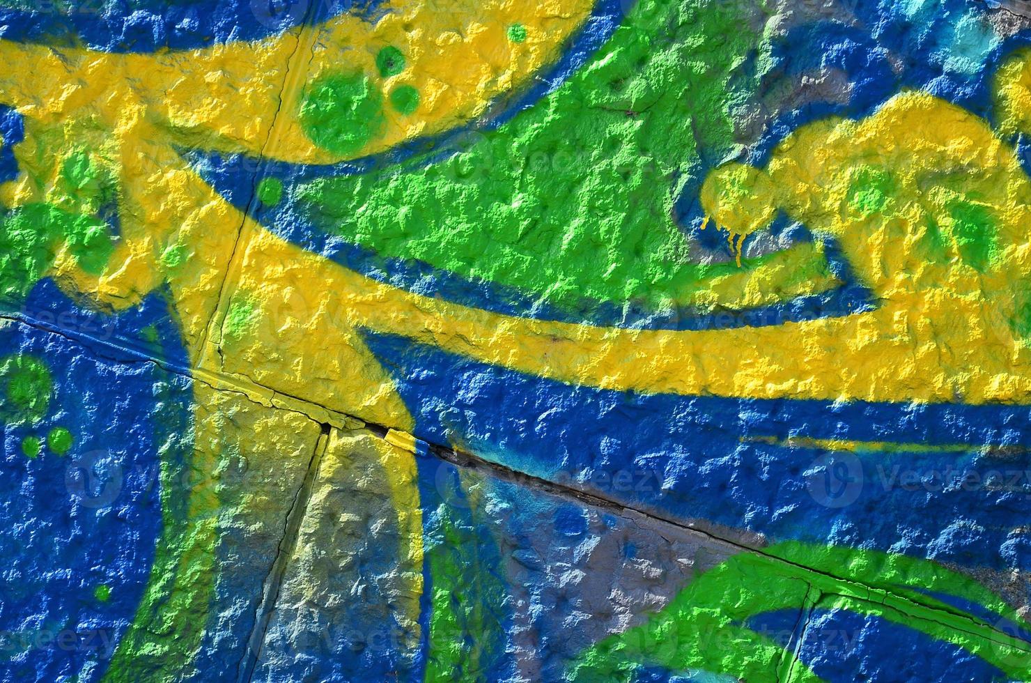 Fragment of graffiti drawings. The old wall decorated with paint stains in the style of street art culture. Colored background texture in green tones photo