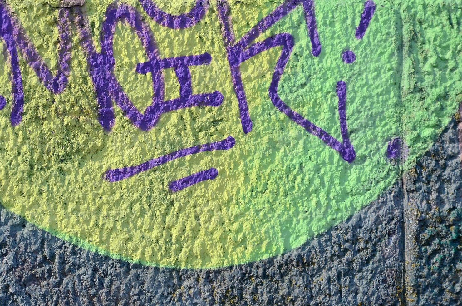 Fragment of graffiti drawings. The old wall decorated with paint stains in the style of street art culture. Colored background texture in warm tones photo