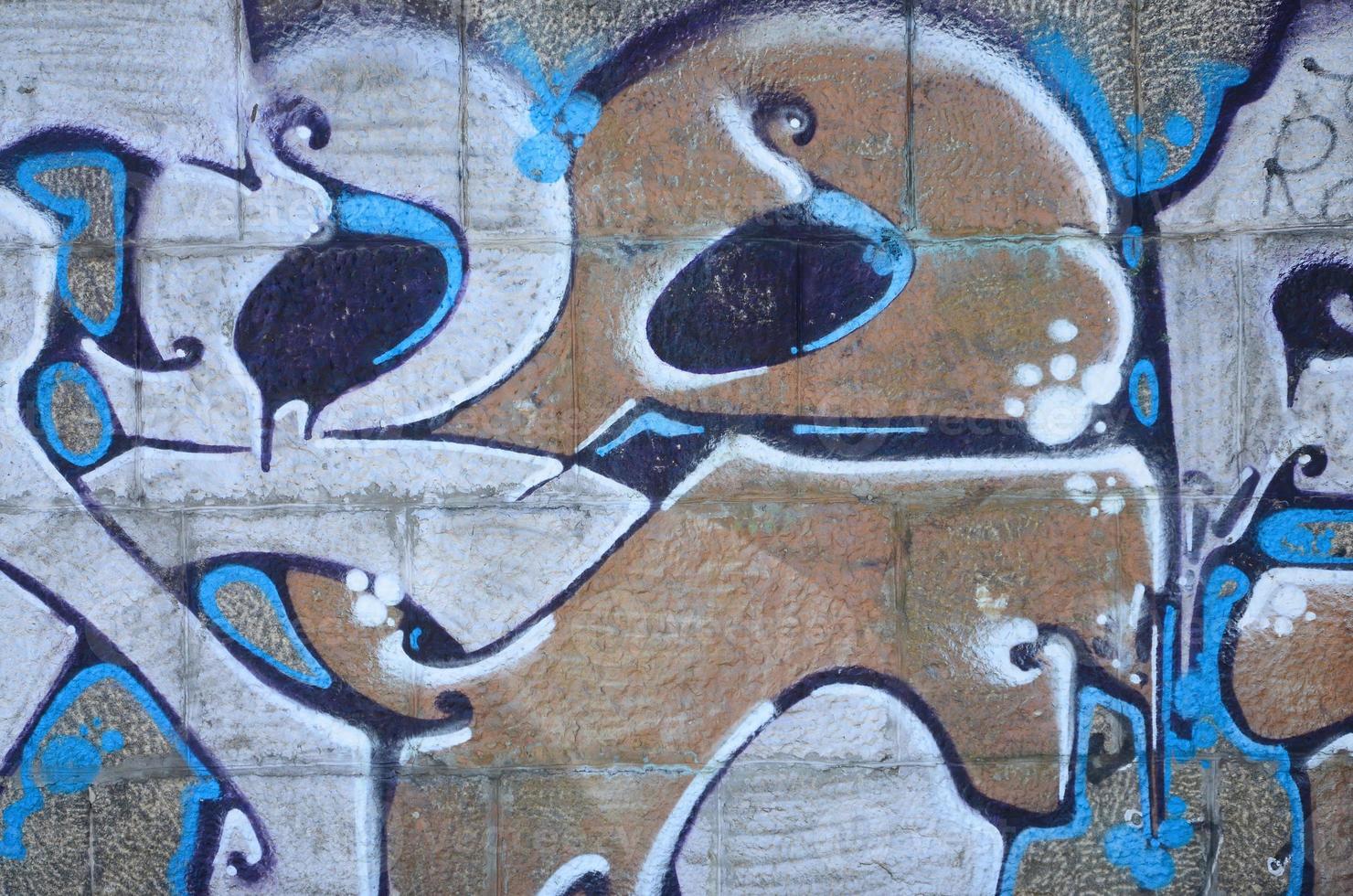 fragmento de dibujos de graffiti. la antigua muralla decorada con manchas de pintura al estilo de la cultura del arte callejero. textura de fondo coloreada en tonos cálidos foto