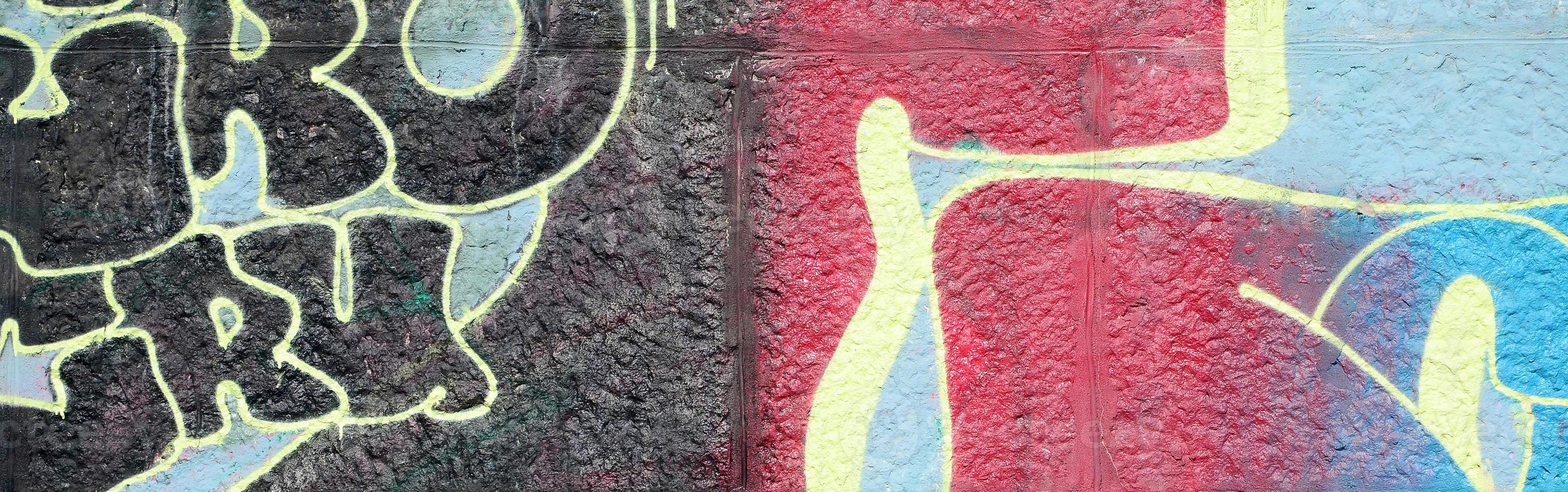 Fragment of graffiti drawings. The old wall decorated with paint stains in the style of street art culture. Multicolored background texture photo