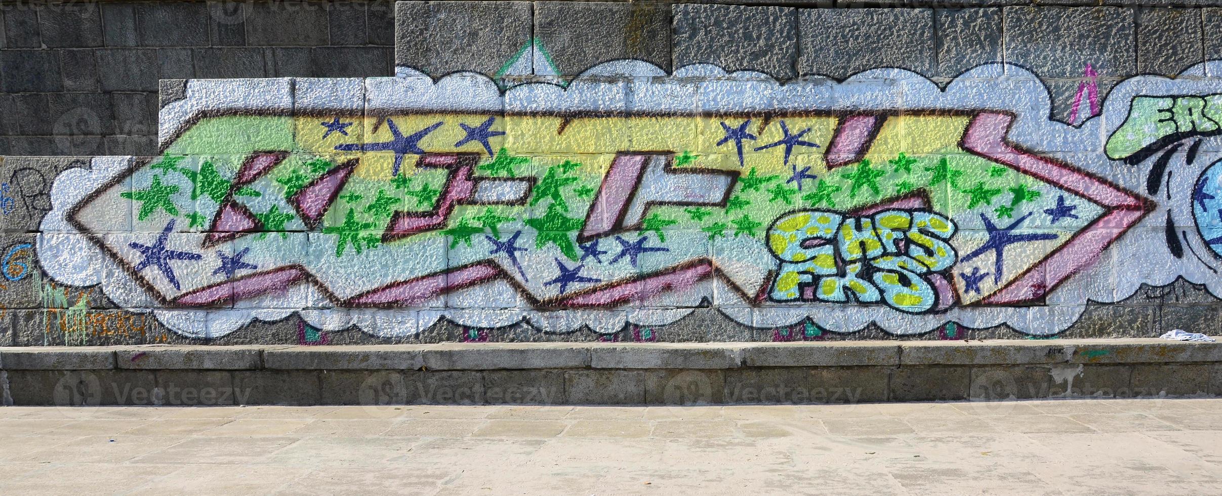 Fragment of graffiti drawings. The old wall decorated with paint stains in the style of street art culture. Colored background texture in green tones photo