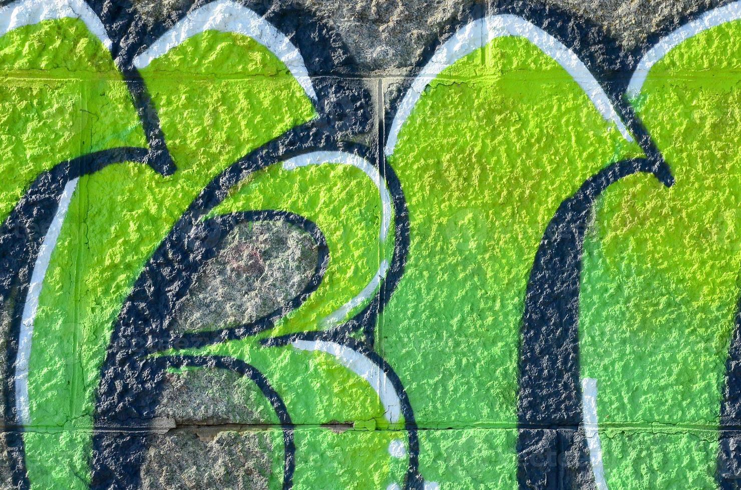 fragmento de dibujos de graffiti. la antigua muralla decorada con manchas de pintura al estilo de la cultura del arte callejero. textura de fondo coloreada en tonos verdes foto