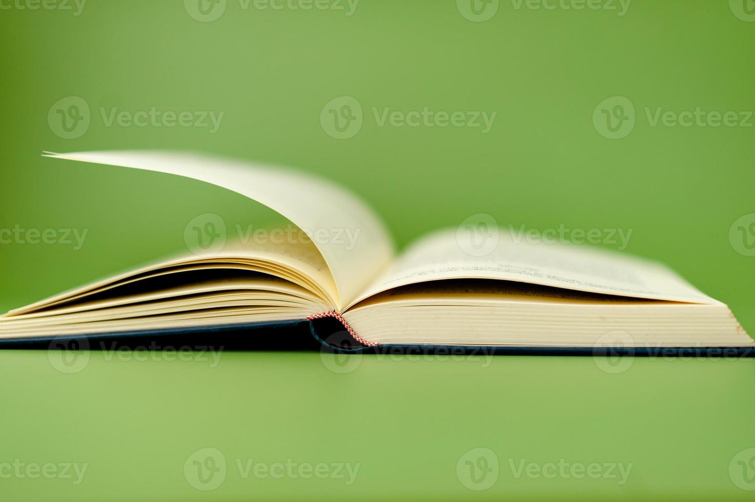 Thick book on green background, reading concept photo