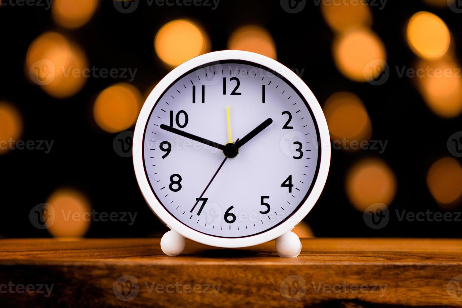 White clock isolated on bokeh lights background photo