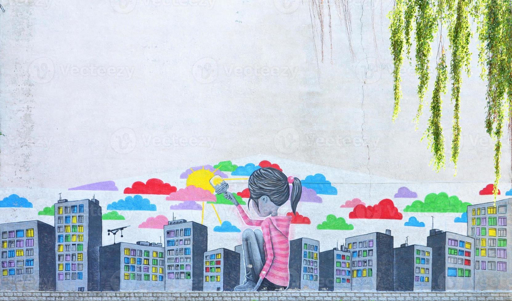 The old wall, painted in color graffiti drawing with aerosol paints. Picture of a little girl who draws a lot of skyscrapers with a brush with paints photo