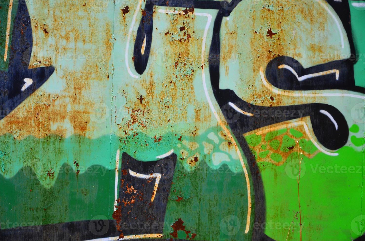 The old wall, painted in color graffiti drawing green aerosol paints. Background image on the theme of drawing graffiti and street art photo