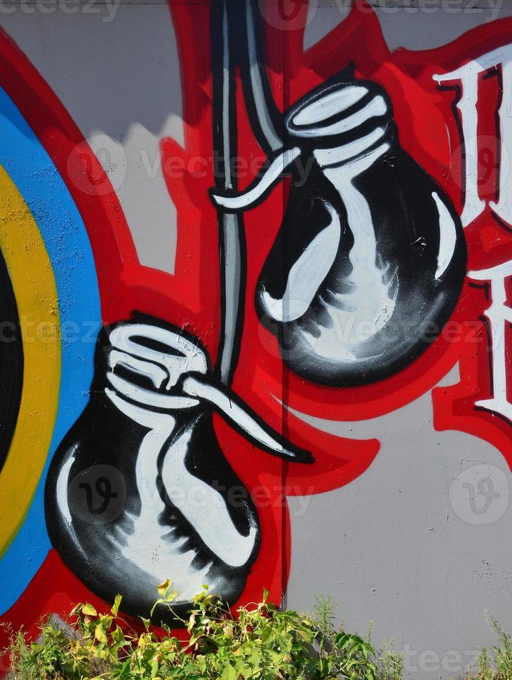 The old wall, painted in color graffiti drawing with aerosol paints. The image of red boxing gloves hanging on the wall photo