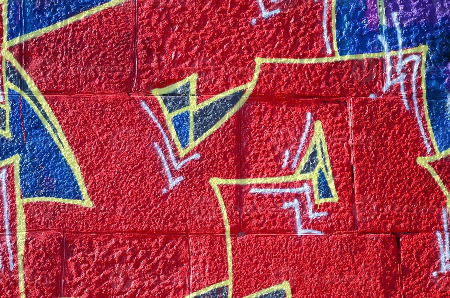 Fragment of graffiti drawings. The old wall decorated with paint stains in the style of street art culture. Colored background texture in warm tones photo