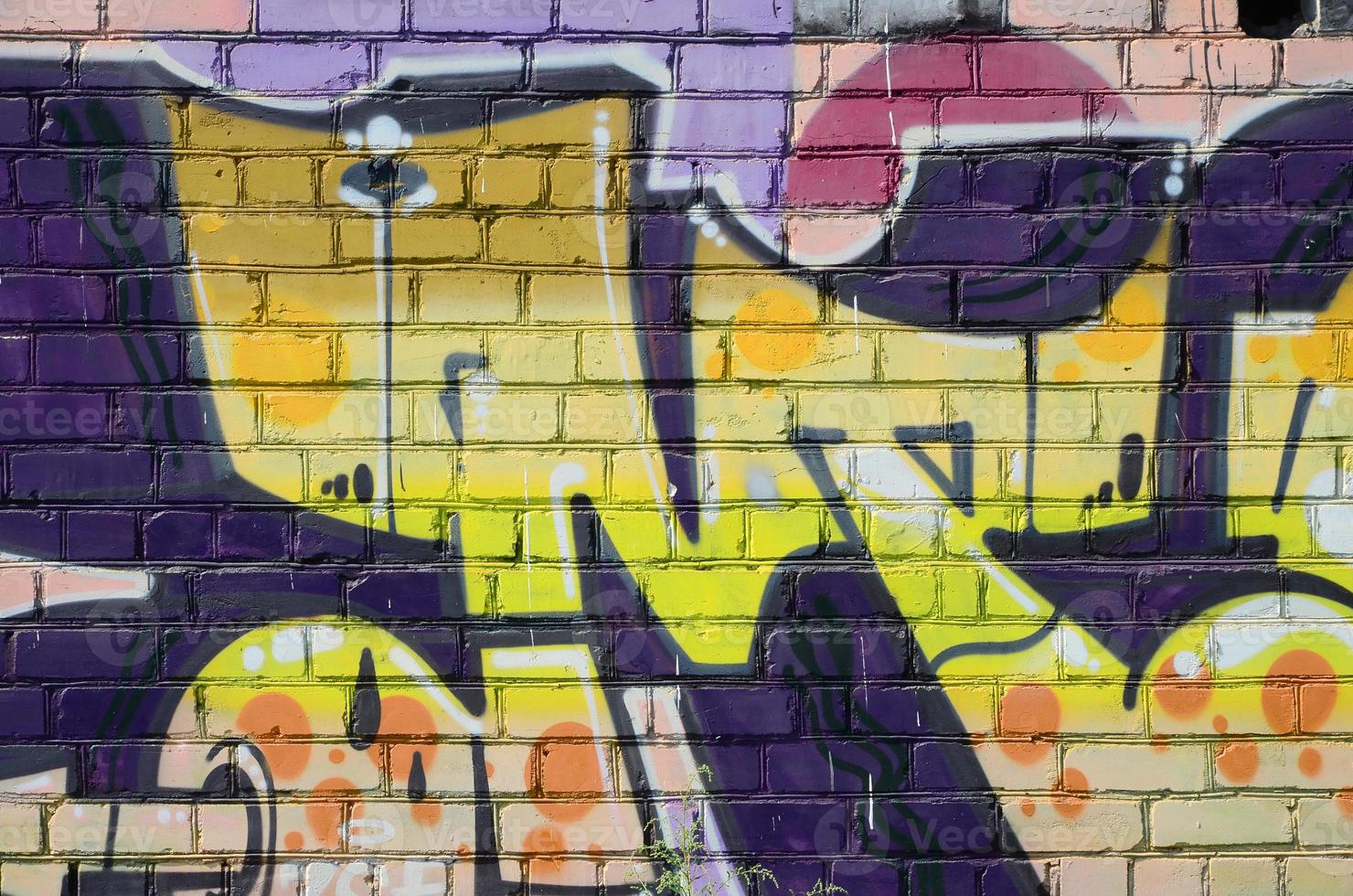 Fragment of graffiti drawings. The old wall decorated with paint stains in the style of street art culture. Colored background texture in warm tones photo