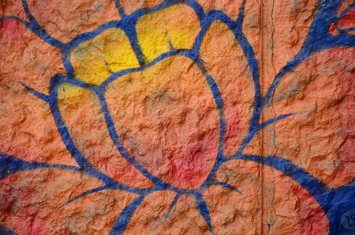 Fragment of graffiti drawings. The old wall decorated with paint stains in the style of street art culture. Orange flower photo