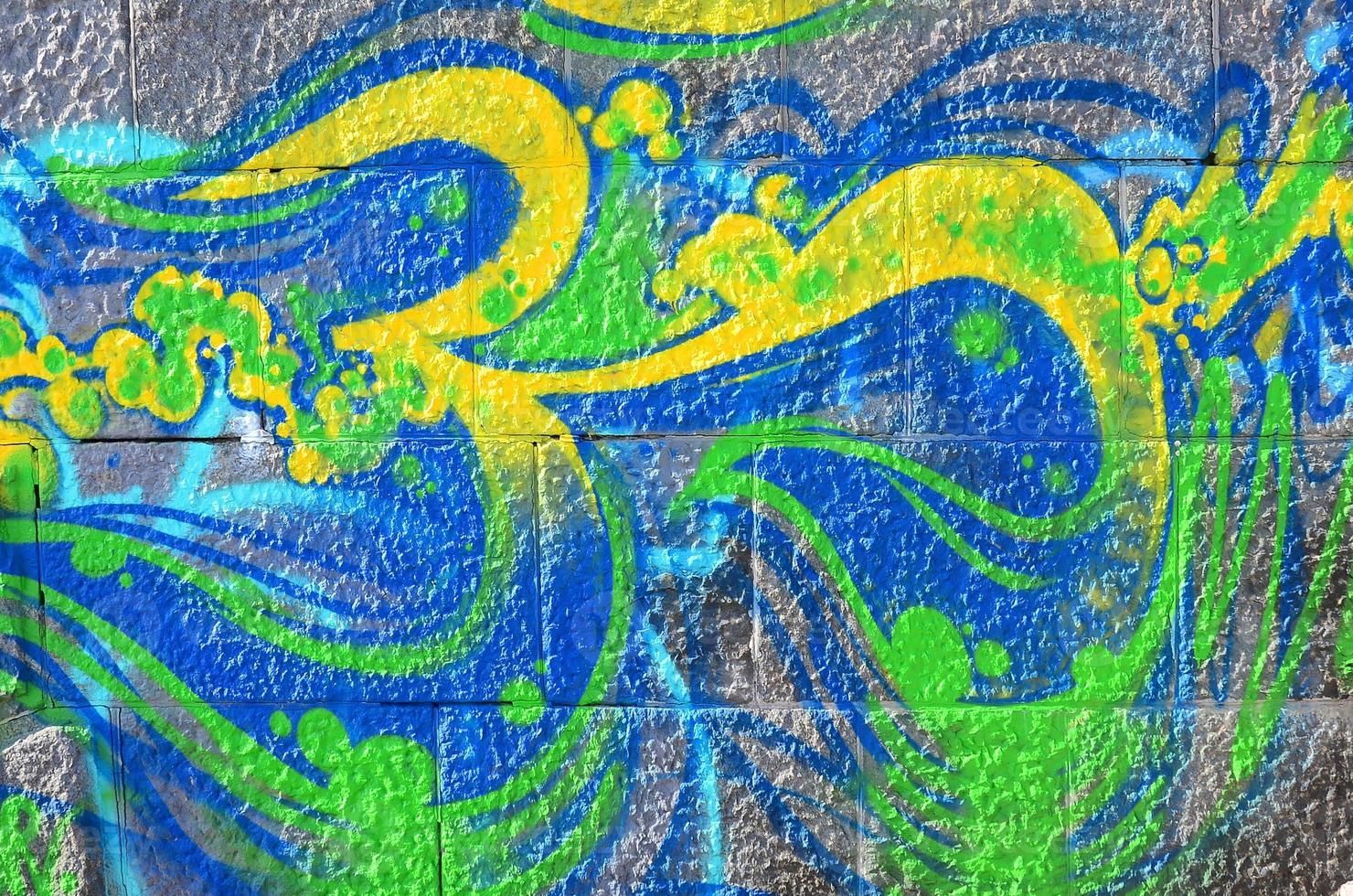 fragmento de dibujos de graffiti. la antigua muralla decorada con manchas de pintura al estilo de la cultura del arte callejero. textura de fondo coloreada en tonos verdes foto