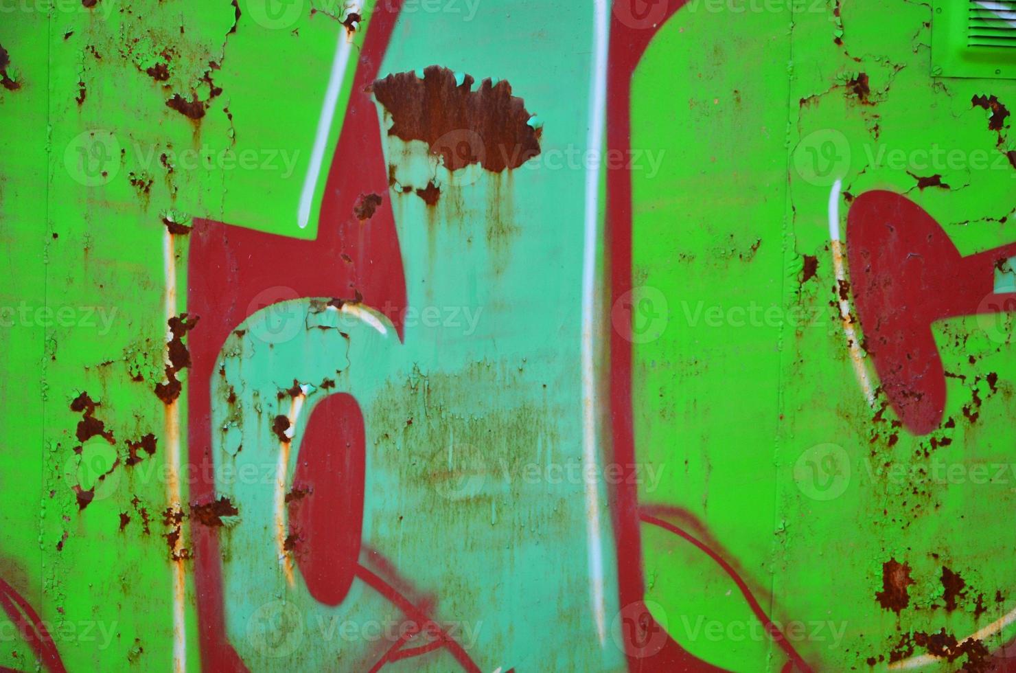 The old wall, painted in color graffiti drawing green aerosol paints. Background image on the theme of drawing graffiti and street art photo