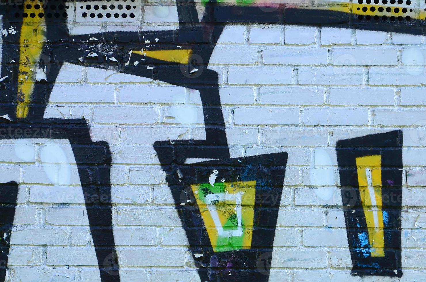 Fragment of graffiti drawings. The old wall decorated with paint stains in the style of street art culture. Colored background texture photo