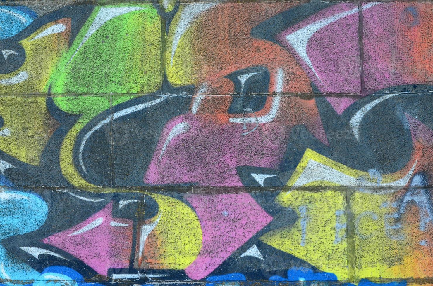 Fragment of graffiti drawings. The old wall decorated with paint stains in the style of street art culture. Multicolored background texture photo
