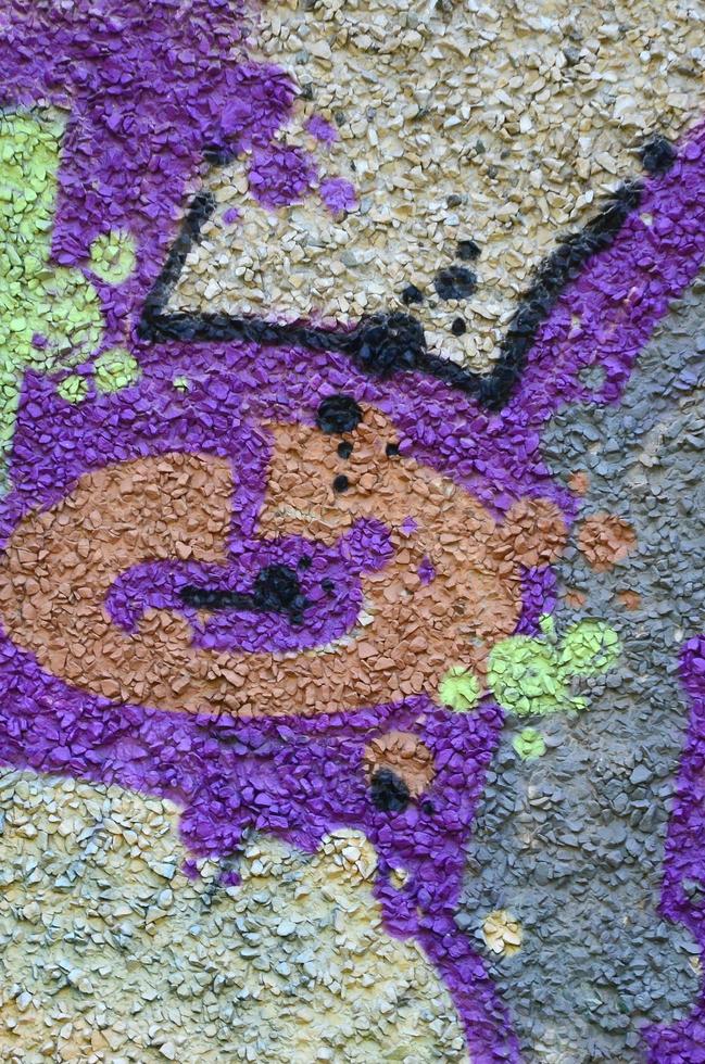 Fragment of graffiti drawings. The old wall decorated with paint stains in the style of street art culture. Colored background texture in warm tones photo