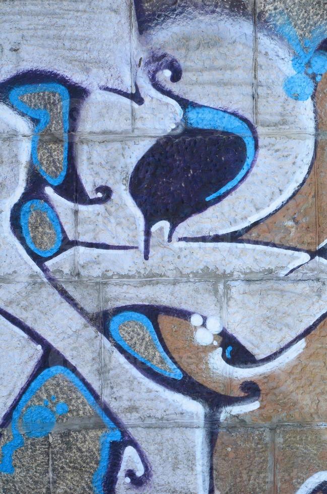 fragmento de dibujos de graffiti. la antigua muralla decorada con manchas de pintura al estilo de la cultura del arte callejero. textura de fondo coloreada en tonos cálidos foto