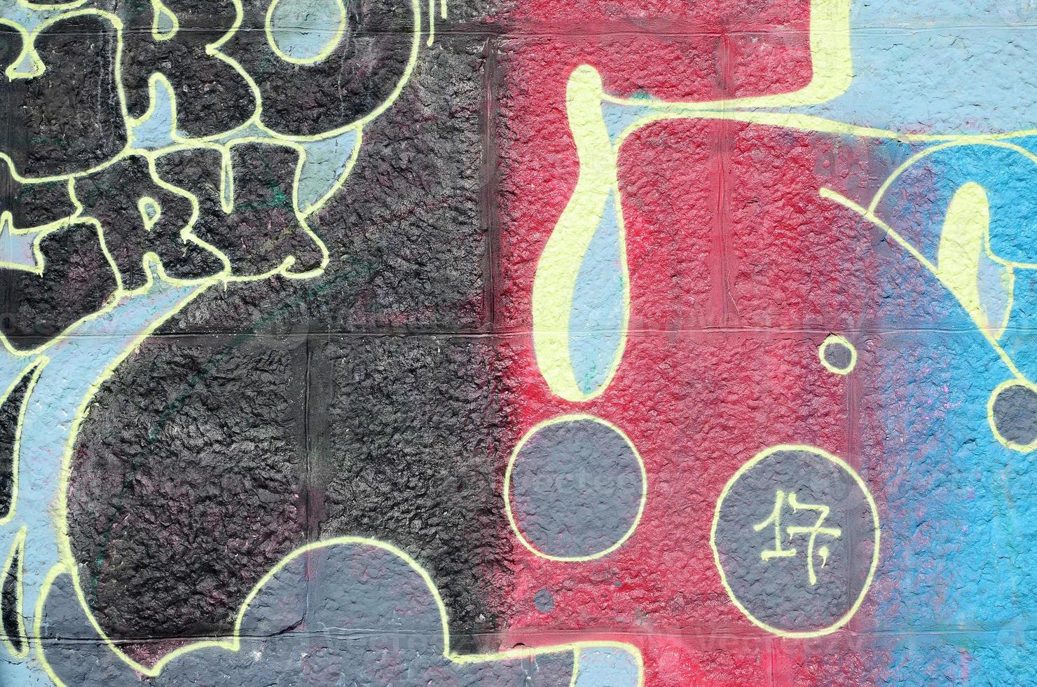 Fragment of graffiti drawings. The old wall decorated with paint stains in the style of street art culture. Multicolored background texture photo