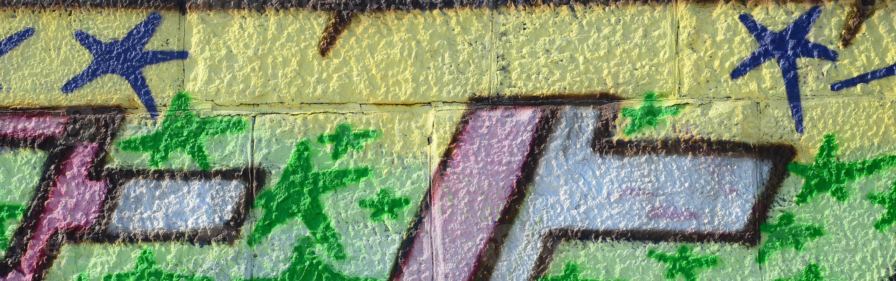 Fragment of graffiti drawings. The old wall decorated with paint stains in the style of street art culture. Colored background texture in green tones photo