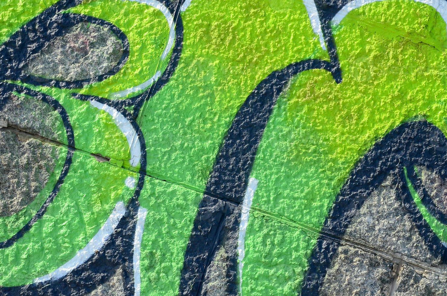 Fragment of graffiti drawings. The old wall decorated with paint stains in the style of street art culture. Colored background texture in green tones photo