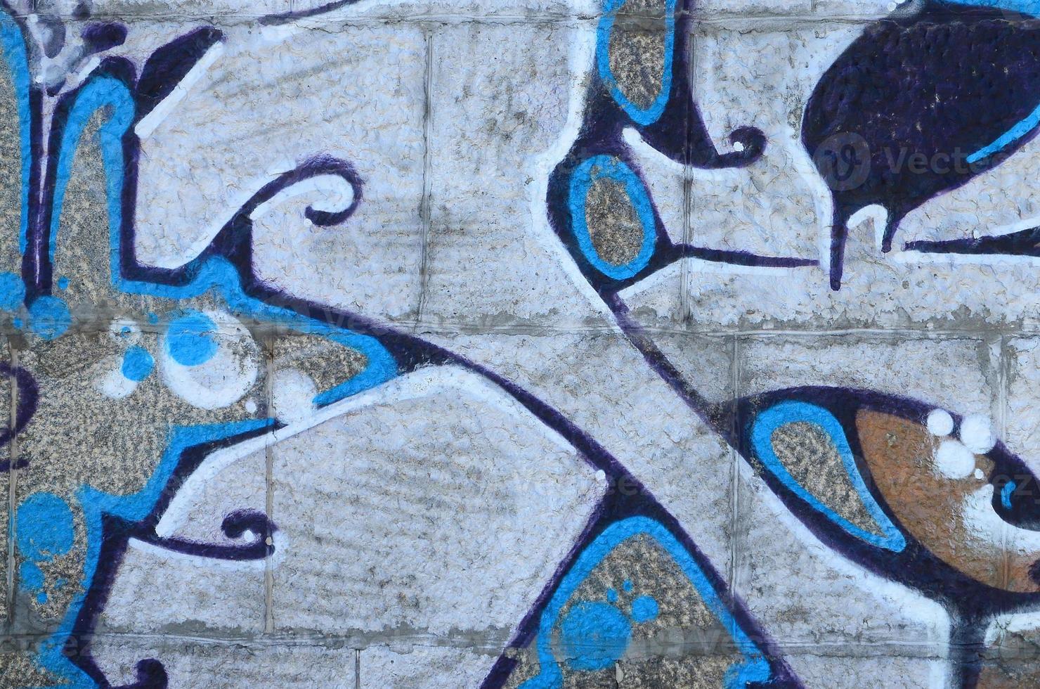 Fragment of graffiti drawings. The old wall decorated with paint stains in the style of street art culture. Colored background texture in warm tones photo