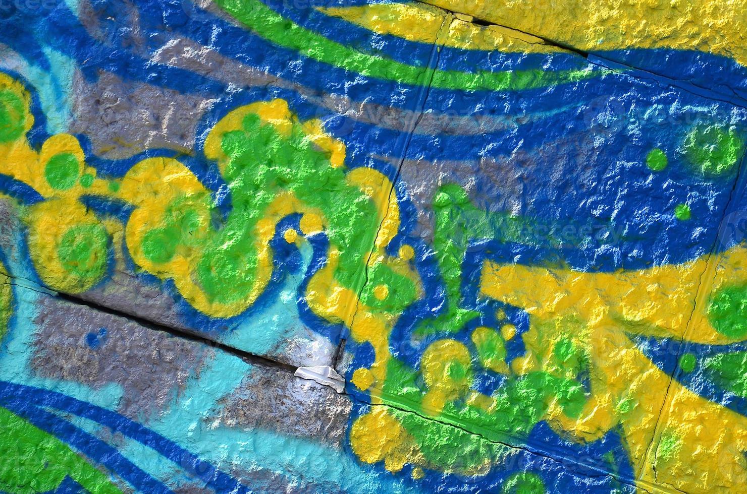 Fragment of graffiti drawings. The old wall decorated with paint stains in the style of street art culture. Colored background texture in green tones photo