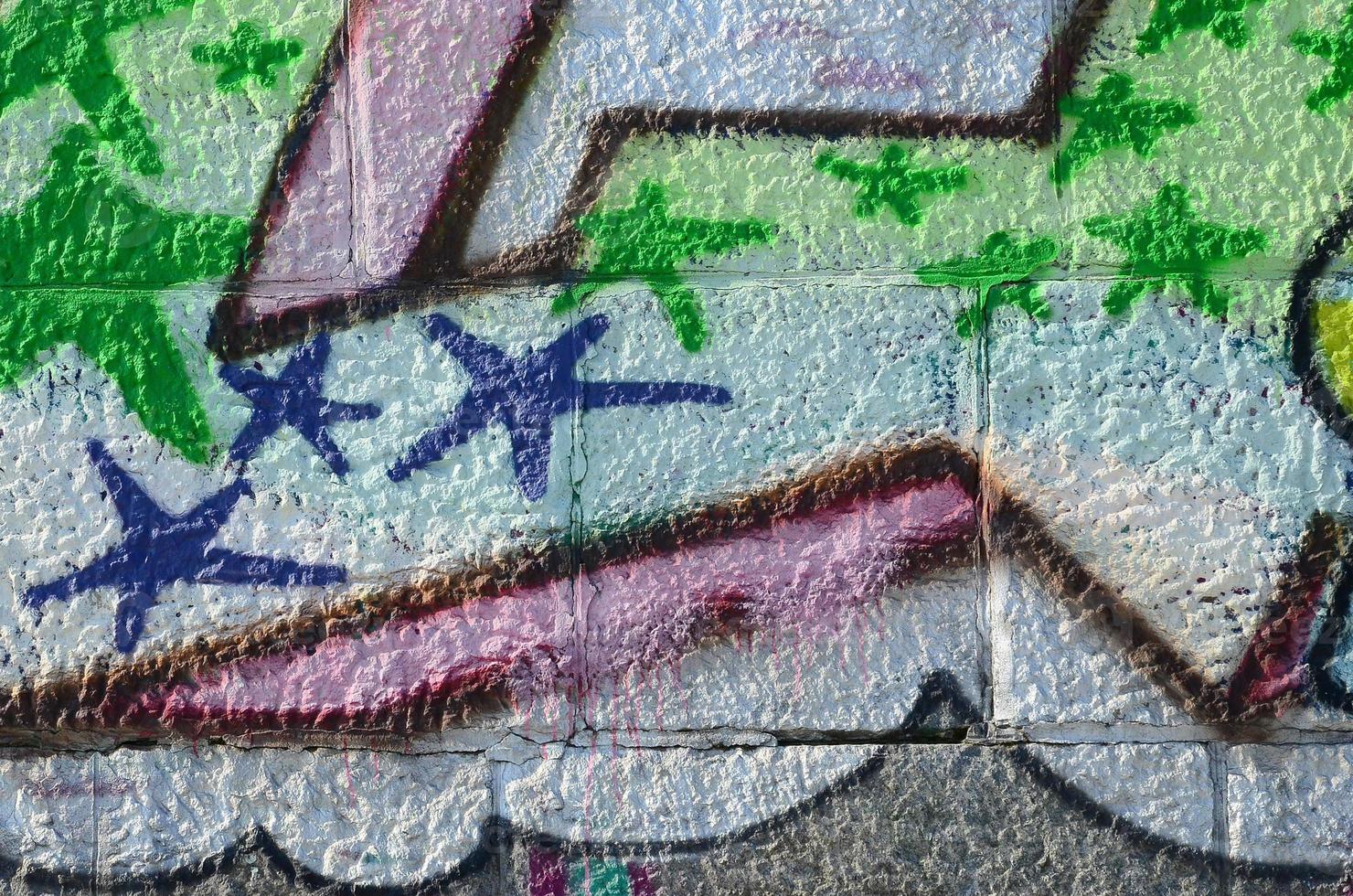 Fragment of graffiti drawings. The old wall decorated with paint stains in the style of street art culture. Colored background texture in green tones photo