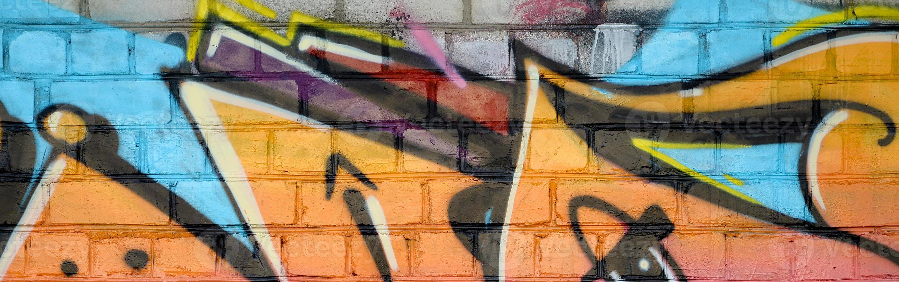 Abstract colorful fragment of graffiti paintings on old brick wall. Street-art composition with parts of wild letters and multicolored stains. Subcultural background texture photo