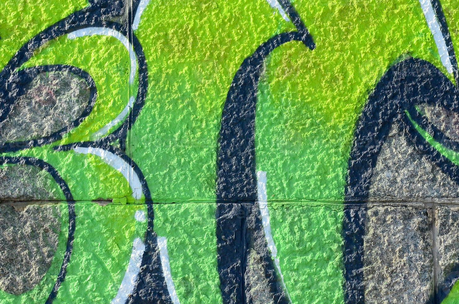 Fragment of graffiti drawings. The old wall decorated with paint stains in the style of street art culture. Colored background texture in green tones photo