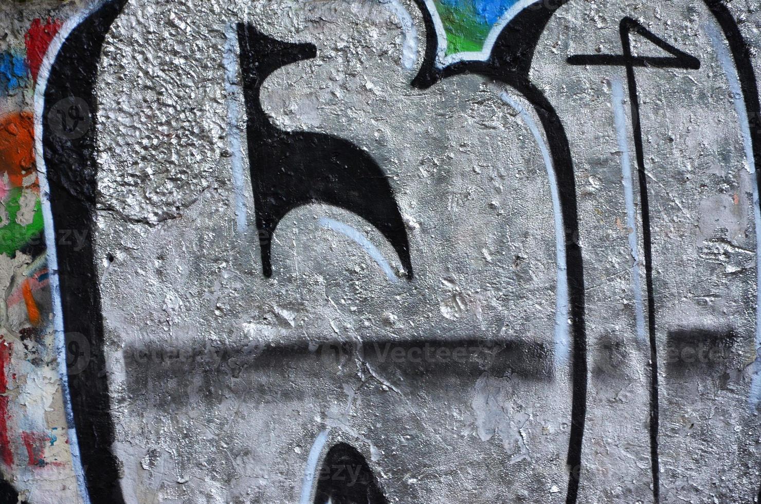 Texture of a fragment of the wall with graffiti painting, which is depicted on it. An image of a piece of graffiti drawing as a photo on street art and graffiti culture topics