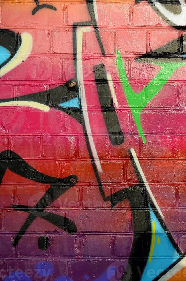 Abstract colorful fragment of graffiti paintings on old brick wall. Street art composition with parts of unwritten letters and multicolored stains. Subcultural background texture photo