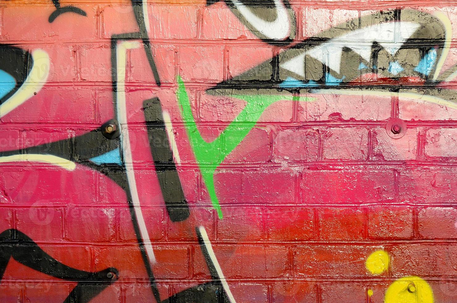 Abstract colorful fragment of graffiti paintings on old brick wall. Street art composition with parts of unwritten letters and multicolored stains. Subcultural background texture photo