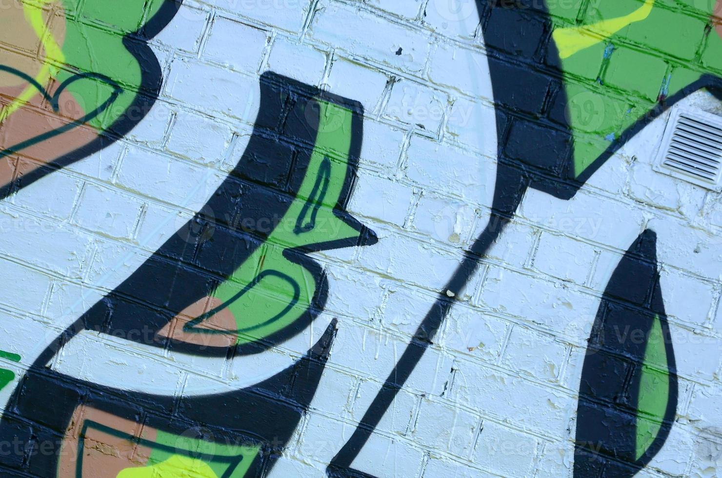 Fragment of graffiti drawings. The old wall decorated with paint stains in the style of street art culture. Colored background texture in green tones photo