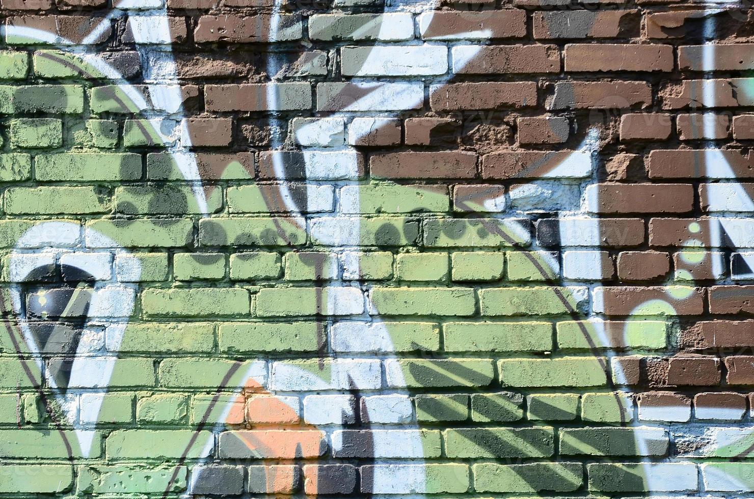 Fragment of graffiti drawings. The old wall decorated with paint stains in the style of street art culture. Colored background texture in warm tones photo